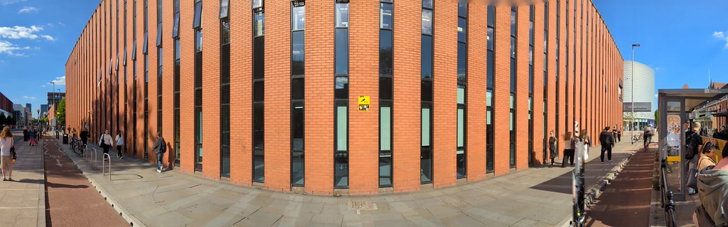 A panoramic picture of the Kilburn building which looks a like a giant brick heat sink. This picture is taken from the Oxford Road showing University Place on the right, which looks like a giant tin of baked beans. Creative Commons BY Image by Yours Truly via Wikimedia Commons w.wiki/E6Qk