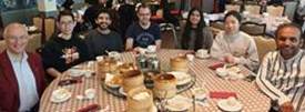 A group of people sitting at a table with food

AI-generated content may be incorrect.