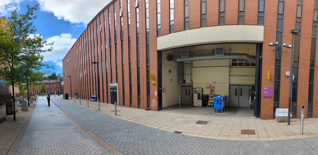 A panoramic picture of the South entrance of the Kilburn building with the Oxford Road on the left hand side of the picture.