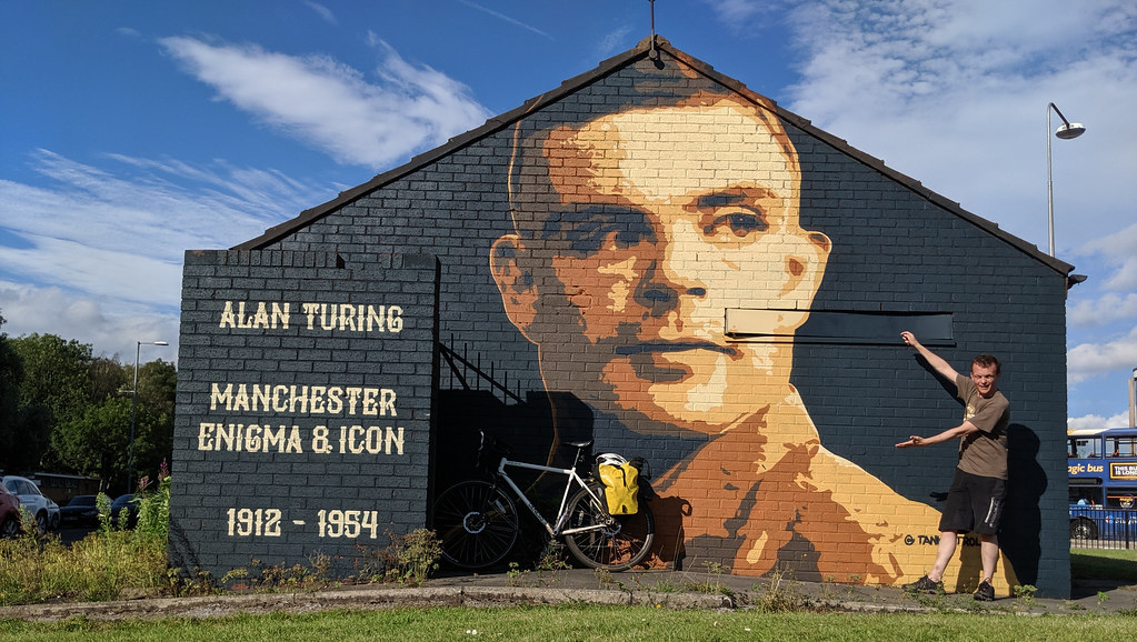 Paying homage to Alan Turing at a mural on the Princess Parkway by tankpetrol.com. According to Jonathan Swinton, Turing is the “patron saint of Manchester” (Swinton 2019). As a Manchester icon, he is commemorated locally by the Alan Turing building, the Alan Turing Memorial, some blue plaques and the Alan Turing Way (Cooksey 2013)